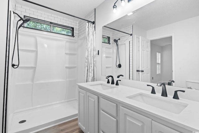 1331 Bermuda Ct, Surfside Beach, SC 29575 - bathroom with curtained shower, double vanity, a textured ceiling, and wood finished floors