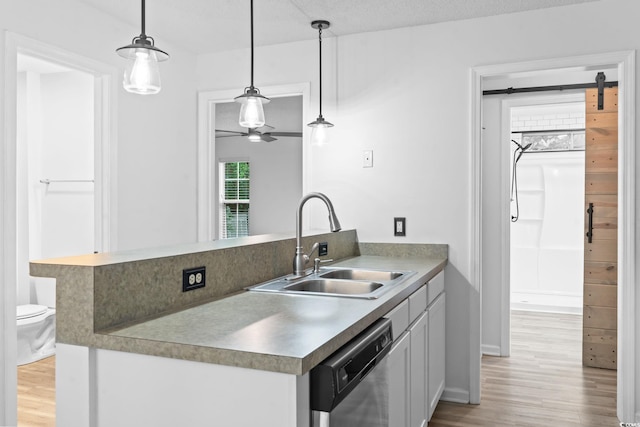 1331 Bermuda Ct, Surfside Beach, SC 29575 - kitchen featuring dishwasher, light wood-type flooring, white cabinets, and decorative light fixtures