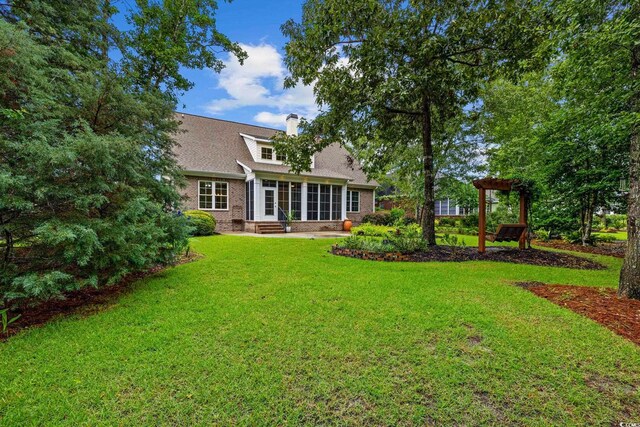 28 Grey Moss Rd, Murrells Inlet, SC 29576 - back of house featuring a chimney, a yard, brick siding, and entry steps