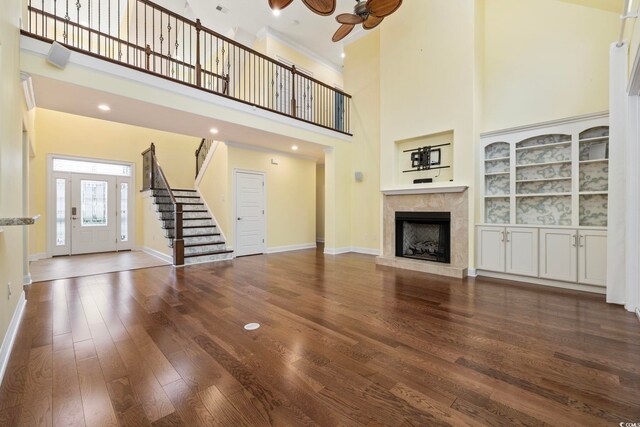 28 Grey Moss Rd, Murrells Inlet, SC 29576 - unfurnished living room with a high ceiling, a ceiling fan, stairs, wood finished floors, and a tiled fireplace