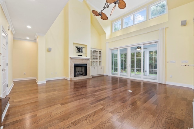 28 Grey Moss Rd, Murrells Inlet, SC 29576 - unfurnished living room featuring a premium fireplace, crown molding, wood finished floors, a high ceiling, and ceiling fan