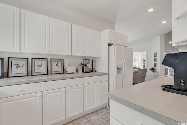 1208 Trisail Ln, North Myrtle Beach, SC 29582 - kitchen with white fridge with ice dispenser, white cabinets, light countertops, light tile patterned flooring, and recessed lighting