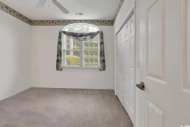 1208 Trisail Ln, North Myrtle Beach, SC 29582 - unfurnished bedroom with carpet, a closet, ceiling fan, and a textured ceiling