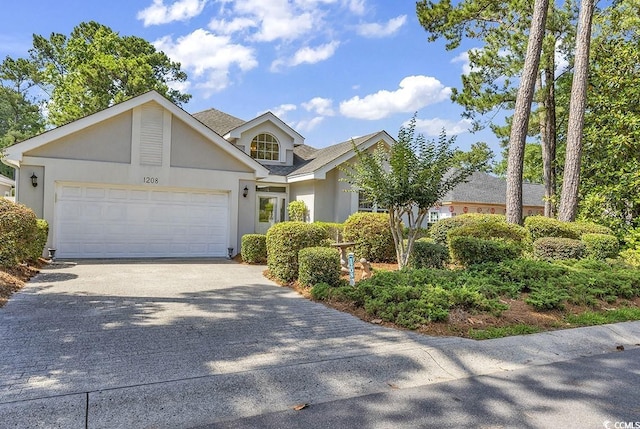 1208 Trisail Ln, North Myrtle Beach, SC 29582 - view of front facade with concrete driveway, a garage, stucco siding, and roof with shingles