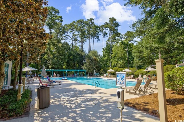 1208 Trisail Ln, North Myrtle Beach, SC 29582 - community pool with a patio area and view of wooded area