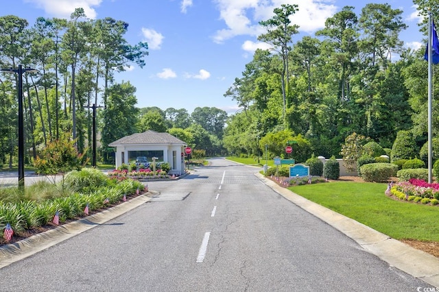 1208 Trisail Ln, North Myrtle Beach, SC 29582 - view of asphalt road featuring curbs, street lighting, and traffic signs