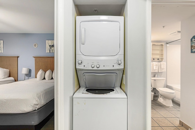 2201 S Ocean Blvd Unit 103, Myrtle Beach, SC 29577 - laundry area with stacked washing machine and dryer and light tile patterned flooring