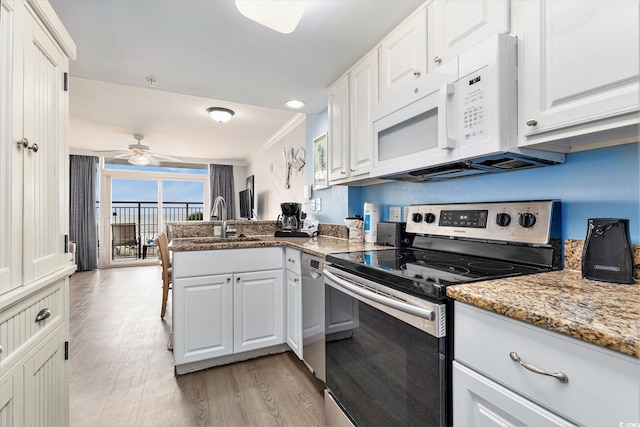 2201 S Ocean Blvd Unit 103, Myrtle Beach, SC 29577 - kitchen with stainless steel appliances, a peninsula, light wood-style flooring, white cabinetry, and ornamental molding