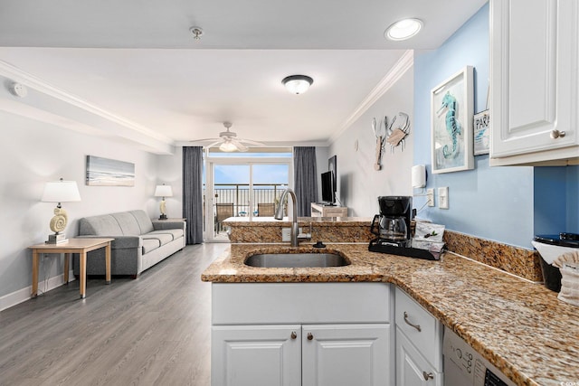 2201 S Ocean Blvd Unit 103, Myrtle Beach, SC 29577 - kitchen featuring a peninsula, white cabinetry, open floor plan, crown molding, and light stone counters