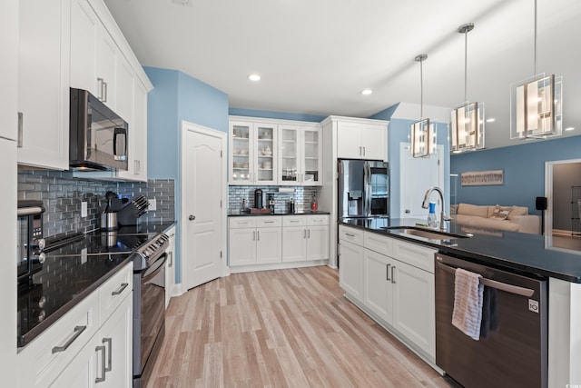 2885 Desert Rose St, Little River, SC 29566 - kitchen featuring appliances with stainless steel finishes, dark countertops, light wood finished floors, tasteful backsplash, and glass insert cabinets