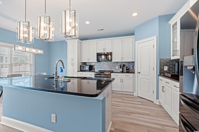 2885 Desert Rose St, Little River, SC 29566 - kitchen with appliances with stainless steel finishes, dark countertops, light wood-type flooring, backsplash, and recessed lighting