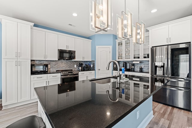 2885 Desert Rose St, Little River, SC 29566 - kitchen featuring appliances with stainless steel finishes, backsplash, an island with sink, light wood-type flooring, and recessed lighting