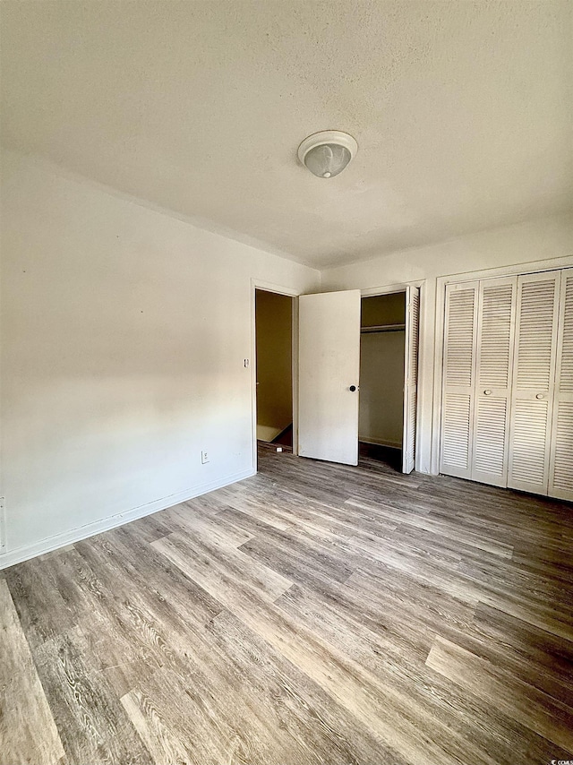 1025 Carolina Rd Unit H4, Conway, SC 29526 - unfurnished bedroom featuring two closets, wood finished floors, and a textured ceiling