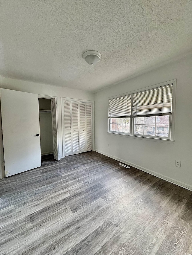 1025 Carolina Rd Unit H4, Conway, SC 29526 - unfurnished bedroom featuring two closets, a textured ceiling, and wood finished floors
