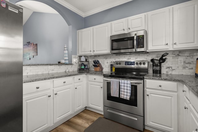 6015 Catalina Dr Unit 932, North Myrtle Beach, SC 29582 - kitchen with appliances with stainless steel finishes, ornamental molding, arched walkways, tasteful backsplash, and white cabinetry