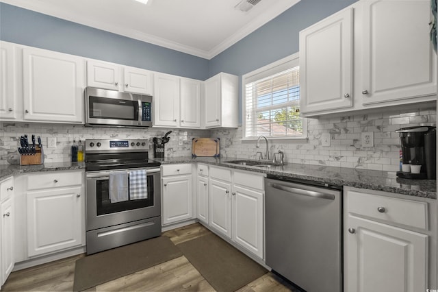 6015 Catalina Dr Unit 932, North Myrtle Beach, SC 29582 - kitchen with stainless steel appliances, crown molding, white cabinetry, tasteful backsplash, and light wood finished floors