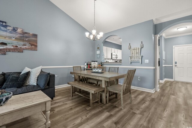 6015 Catalina Dr Unit 932, North Myrtle Beach, SC 29582 - dining space with arched walkways, wood finished floors, crown molding, a chandelier, and high vaulted ceiling