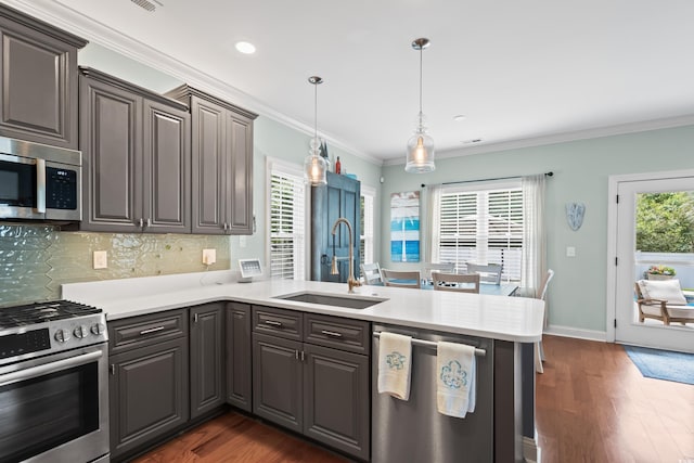 5 Ruth St, Murrells Inlet, SC 29576 - kitchen featuring stainless steel appliances, a peninsula, dark wood-style floors, decorative backsplash, and crown molding