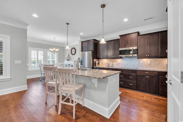 700 Shell Point Ct, Longs, SC 29568 - kitchen featuring stainless steel appliances, crown molding, decorative backsplash, a kitchen breakfast bar, and dark brown cabinets