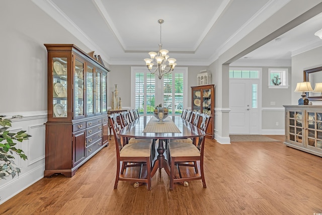 700 Shell Point Ct, Longs, SC 29568 - dining room featuring a chandelier, a raised ceiling, light wood-type flooring, a decorative wall, and a wainscoted wall