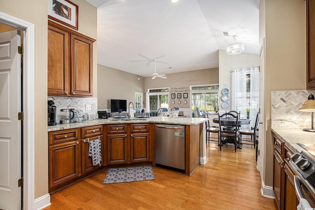 388 Sea Turtle Dr, Myrtle Beach, SC 29588 - kitchen featuring appliances with stainless steel finishes, a peninsula, light wood finished floors, backsplash, and vaulted ceiling