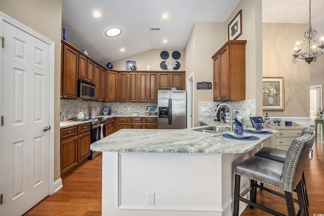 388 Sea Turtle Dr, Myrtle Beach, SC 29588 - kitchen with appliances with stainless steel finishes, a peninsula, a chandelier, backsplash, and light stone countertops