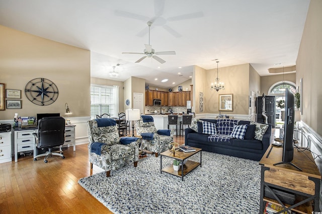 388 Sea Turtle Dr, Myrtle Beach, SC 29588 - living room featuring a desk, vaulted ceiling, light wood-style flooring, a ceiling fan, and a chandelier