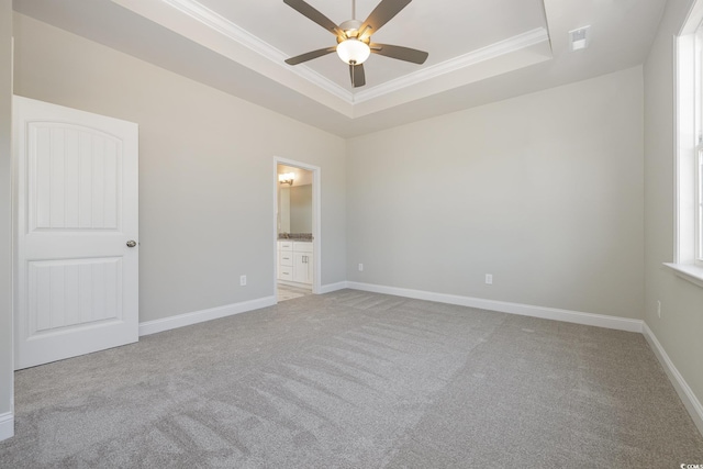 369 Log Cabin Rd, Loris, SC 29569 - unfurnished bedroom featuring light colored carpet, a tray ceiling, crown molding, ensuite bath, and a ceiling fan