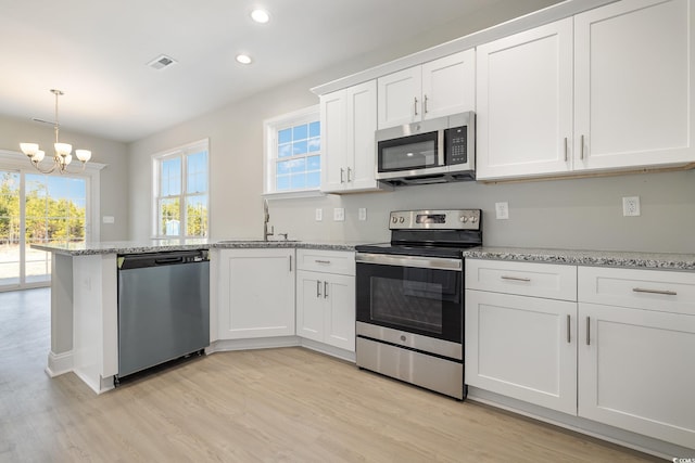 369 Log Cabin Rd, Loris, SC 29569 - kitchen with appliances with stainless steel finishes, a chandelier, white cabinets, a peninsula, and recessed lighting