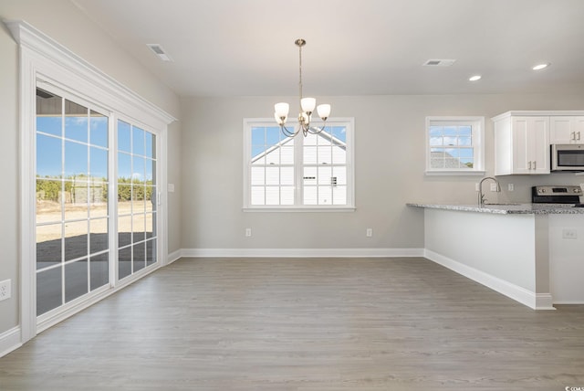 369 Log Cabin Rd, Loris, SC 29569 - kitchen featuring appliances with stainless steel finishes, a chandelier, light wood-style flooring, white cabinets, and light stone counters