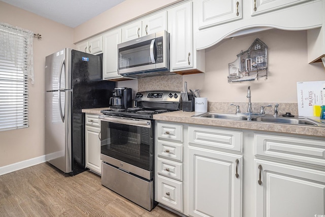 5505 N Ocean Blvd Unit 303, Myrtle Beach, SC 29577 - kitchen with stainless steel appliances, light wood-style flooring, white cabinets, and light countertops