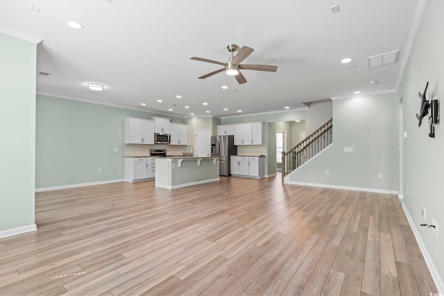 597 Heritage Downs Dr, Conway, SC 29526 - unfurnished living room with a ceiling fan, recessed lighting, ornamental molding, light wood finished floors, and stairway