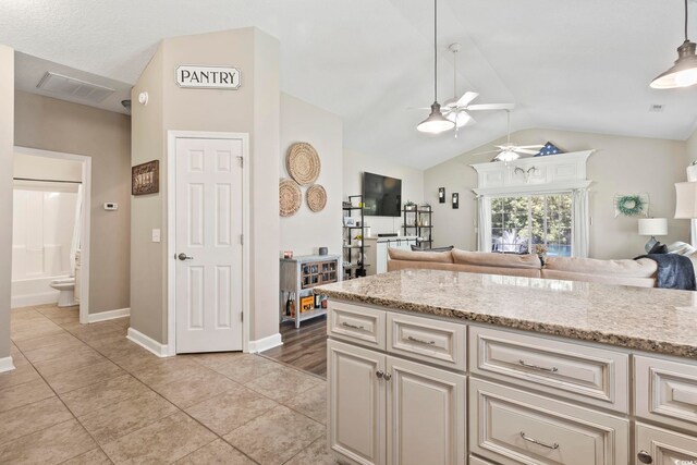 236 Palm Cove Cir, Myrtle Beach, SC 29588 - kitchen featuring a ceiling fan, open floor plan, lofted ceiling, light tile patterned flooring, and light stone countertops
