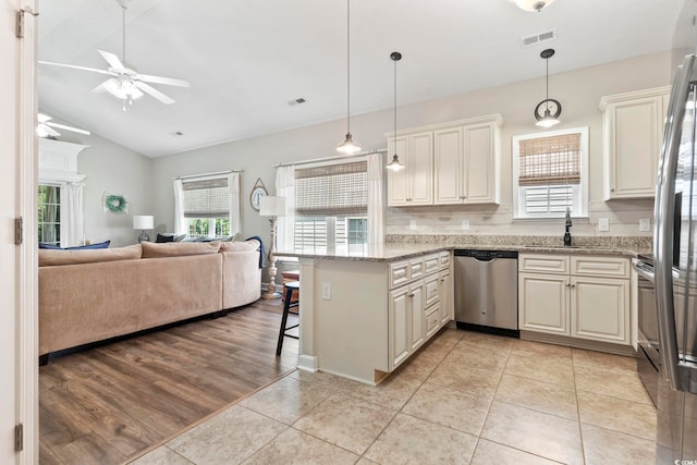 236 Palm Cove Cir, Myrtle Beach, SC 29588 - kitchen with appliances with stainless steel finishes, a peninsula, a ceiling fan, open floor plan, and a kitchen bar