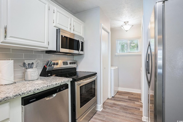1930 Lake View Cir, Myrtle Beach, SC 29575 - kitchen featuring stainless steel appliances, decorative backsplash, white cabinets, light wood finished floors, and a textured ceiling