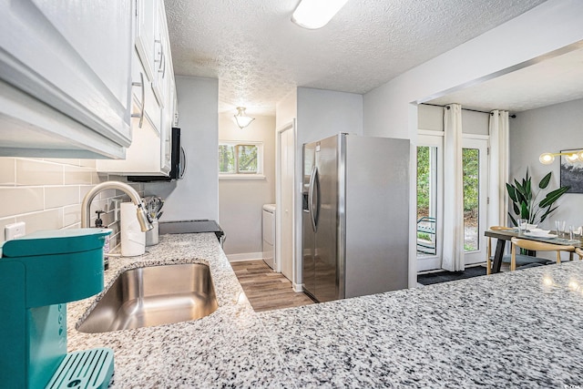 1930 Lake View Cir, Myrtle Beach, SC 29575 - kitchen with stainless steel fridge, light wood-style floors, white cabinets, a textured ceiling, and tasteful backsplash