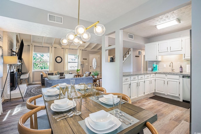 1930 Lake View Cir, Myrtle Beach, SC 29575 - dining area with light wood-style flooring, a chandelier, and stairs