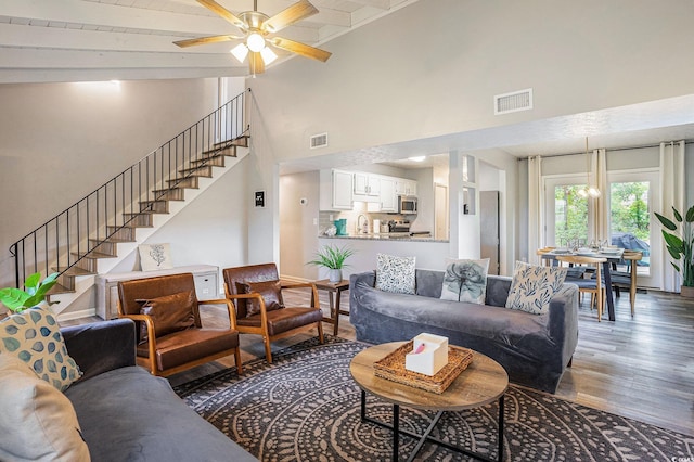 1930 Lake View Cir, Myrtle Beach, SC 29575 - living room featuring wood finished floors, stairs, ceiling fan, beam ceiling, and high vaulted ceiling