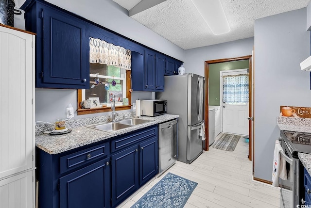 201 Surrey Ln, Myrtle Beach, SC 29579 - kitchen with stainless steel appliances, blue cabinets, light countertops, a textured ceiling, and light wood-style flooring