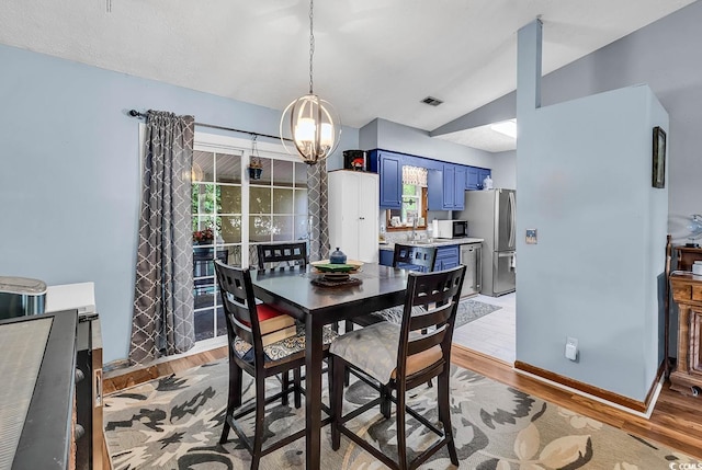 201 Surrey Ln, Myrtle Beach, SC 29579 - dining space with lofted ceiling, light wood-style flooring, a chandelier, and healthy amount of natural light