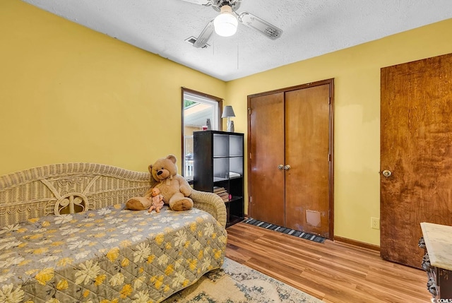 201 Surrey Ln, Myrtle Beach, SC 29579 - bedroom featuring wood finished floors, a textured ceiling, a closet, and a ceiling fan