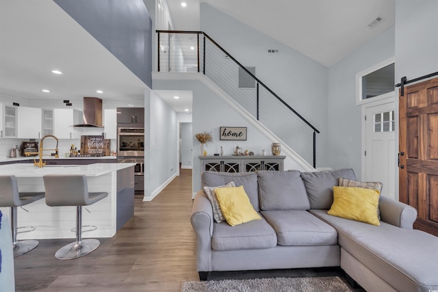 35 Easter Lilly Ct, Murrells Inlet, SC 29576 - living room with stairs, a towering ceiling, wood finished floors, recessed lighting, and a barn door