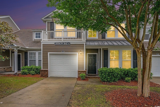 6172 Catalina Dr Unit 414H, North Myrtle Beach, SC 29582 - view of front of house with a standing seam roof, a garage, driveway, brick siding, and a balcony