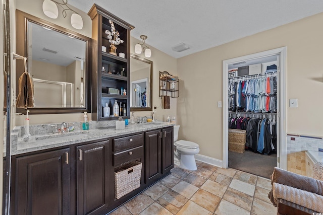 200 Silverbelle Blvd, Longs, SC 29568 - bathroom featuring double vanity, a shower with door, a walk in closet, and stone tile flooring