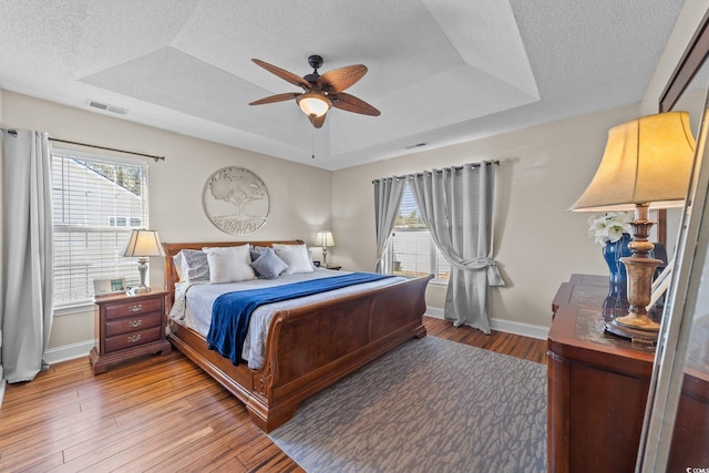 200 Silverbelle Blvd, Longs, SC 29568 - bedroom with a textured ceiling, light wood-type flooring, ceiling fan, and a raised ceiling