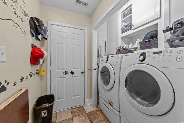200 Silverbelle Blvd, Longs, SC 29568 - laundry area featuring washing machine and dryer, cabinet space, a textured ceiling, and light stone finish floors