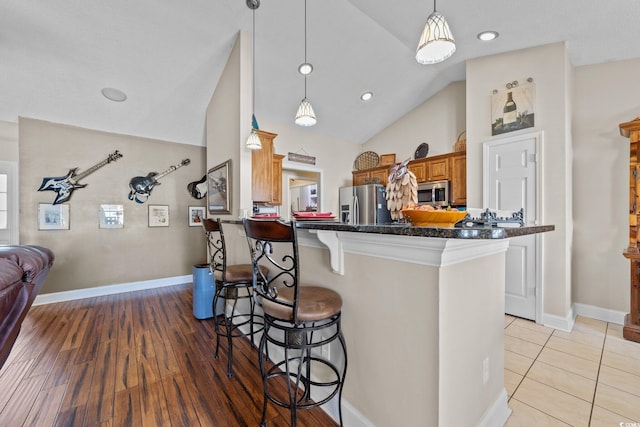 200 Silverbelle Blvd, Longs, SC 29568 - kitchen featuring stainless steel appliances, a kitchen bar, brown cabinets, hanging light fixtures, and recessed lighting