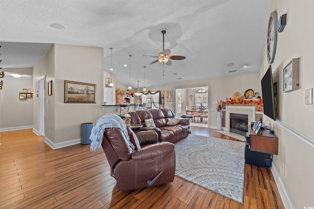 200 Silverbelle Blvd, Longs, SC 29568 - living room with ceiling fan, vaulted ceiling, wood finished floors, and a fireplace with flush hearth