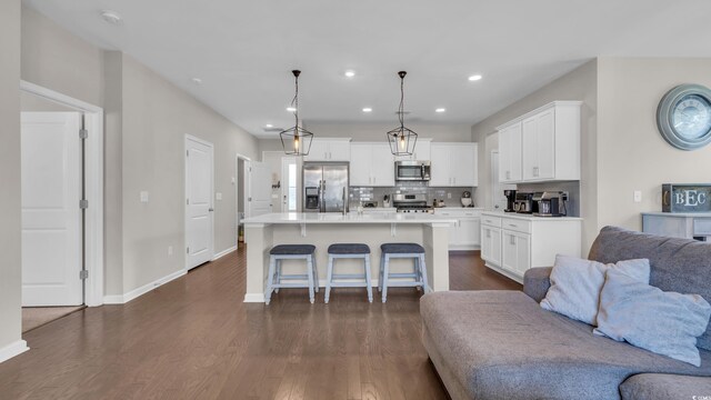 356 Ocean Commons Dr, Surfside Beach, SC 29575 - kitchen featuring open floor plan, stainless steel appliances, a kitchen breakfast bar, dark wood finished floors, and white cabinetry