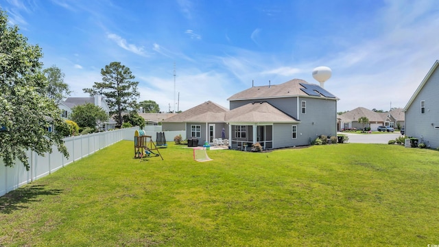356 Ocean Commons Dr, Surfside Beach, SC 29575 - rear view of property featuring a playground, a fenced backyard, a sunroom, and a shingled roof